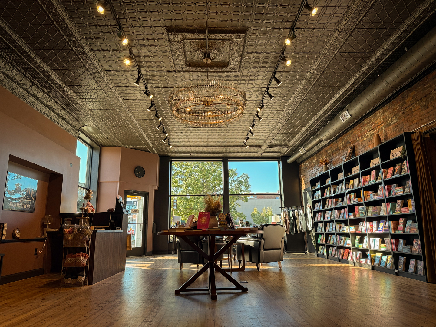 Chandelier above bookcases and tin ceiling